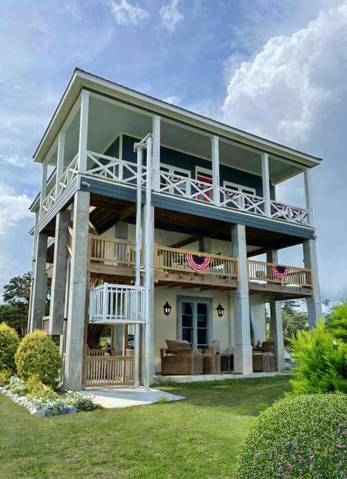 A tall Galaxy cargo lift installation running the full height of a remodeled coastal home with wraparound porches.